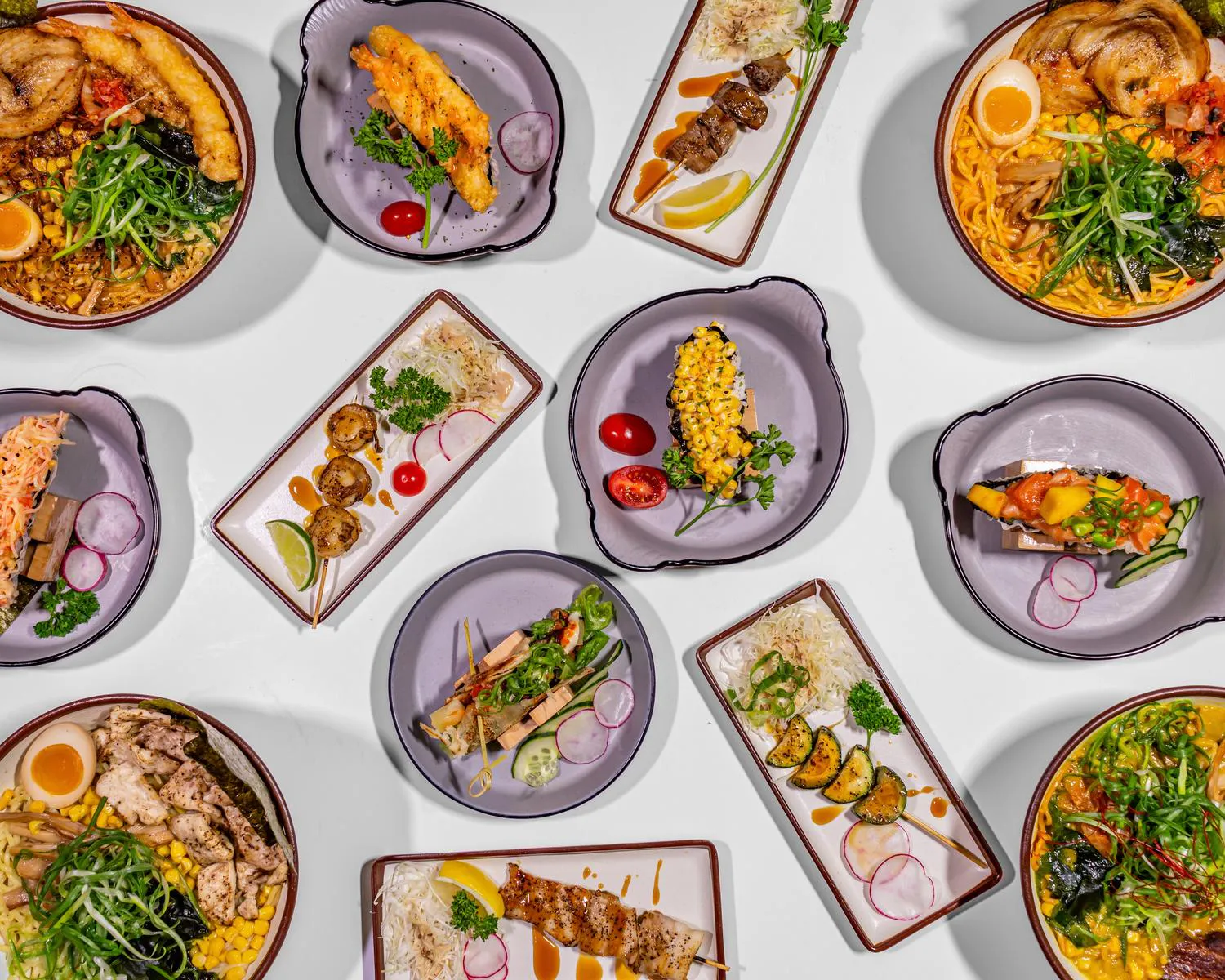 Tonkotsu and Kimchi Ramen bowls with soft-boiled egg and corn, alongside sushi tacos, tempura, yakitori skewers, and poke bowl ingredients